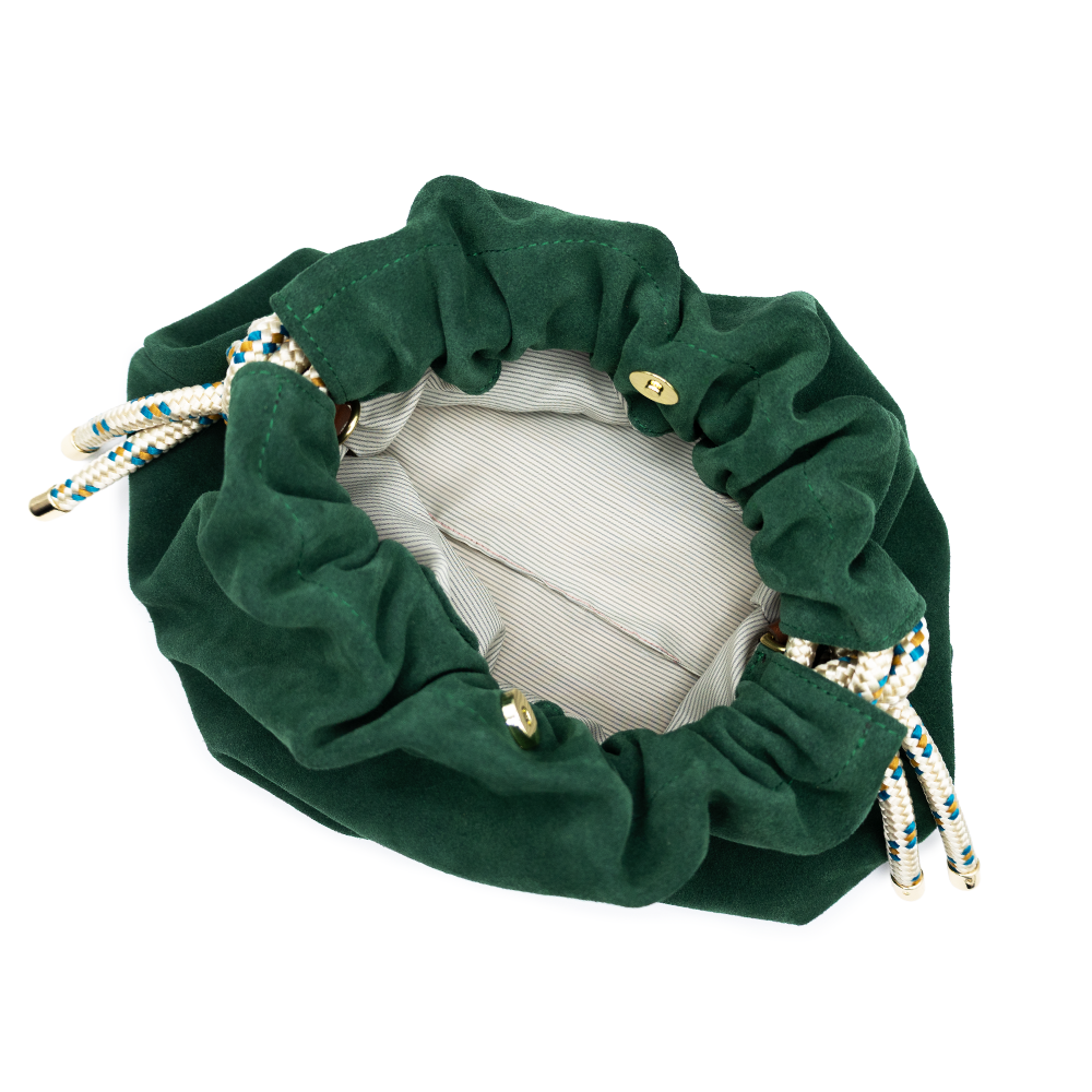 A dark green suede drawstring shoulder bag with a brown leather strap and decorative paracord on the sides, shown against a plain white background.